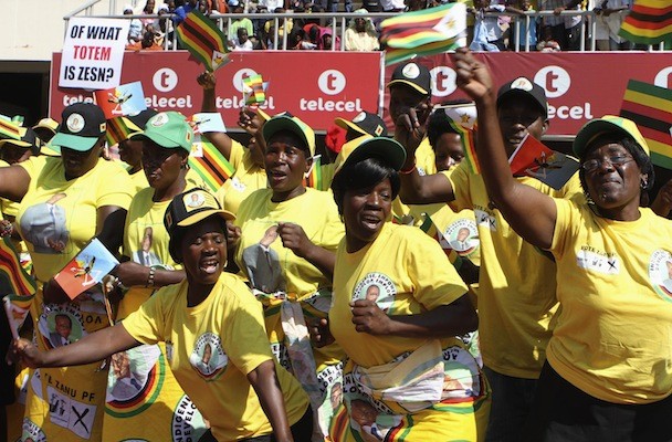 Supporters cheer Zimbabwe's President Robert Mugabe during celebrations to mark the country's Defence Forces Day in the capital Harare, August 13, 2013. Mugabe told critics of his re-election to "go hang" on Monday, making clear he would brook no questioning of his disputed victory either from the West or his main rival, who is challenging the result in court. REUTERS/Philimon Bulawayo (ZIMBABWE - Tags: POLITICS ELECTIONS MILITARY) - RTX12JP9