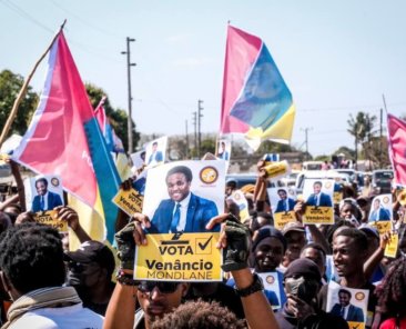 A poster of independent candidate Venacio Mondlane is held at an election rally on Sunday, Oct. 6, 2024 in Maputo ahead of elections in Mozambique. (AP Photo/Carlos Uqueio)